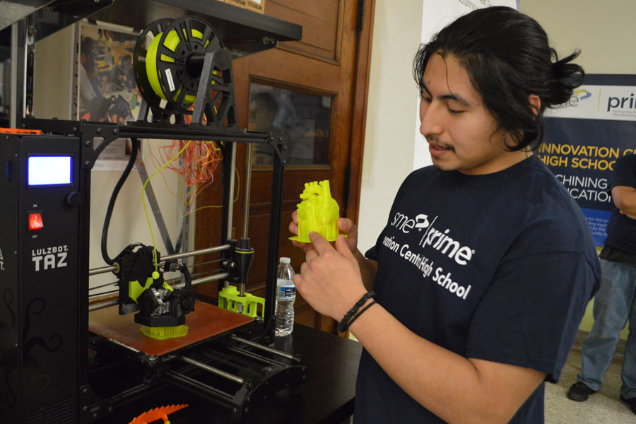 Senior Ociel Romero shows how a 3D printer creates intricate designs